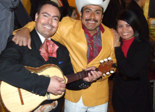 Mariachi guitar player poses for photo with fans